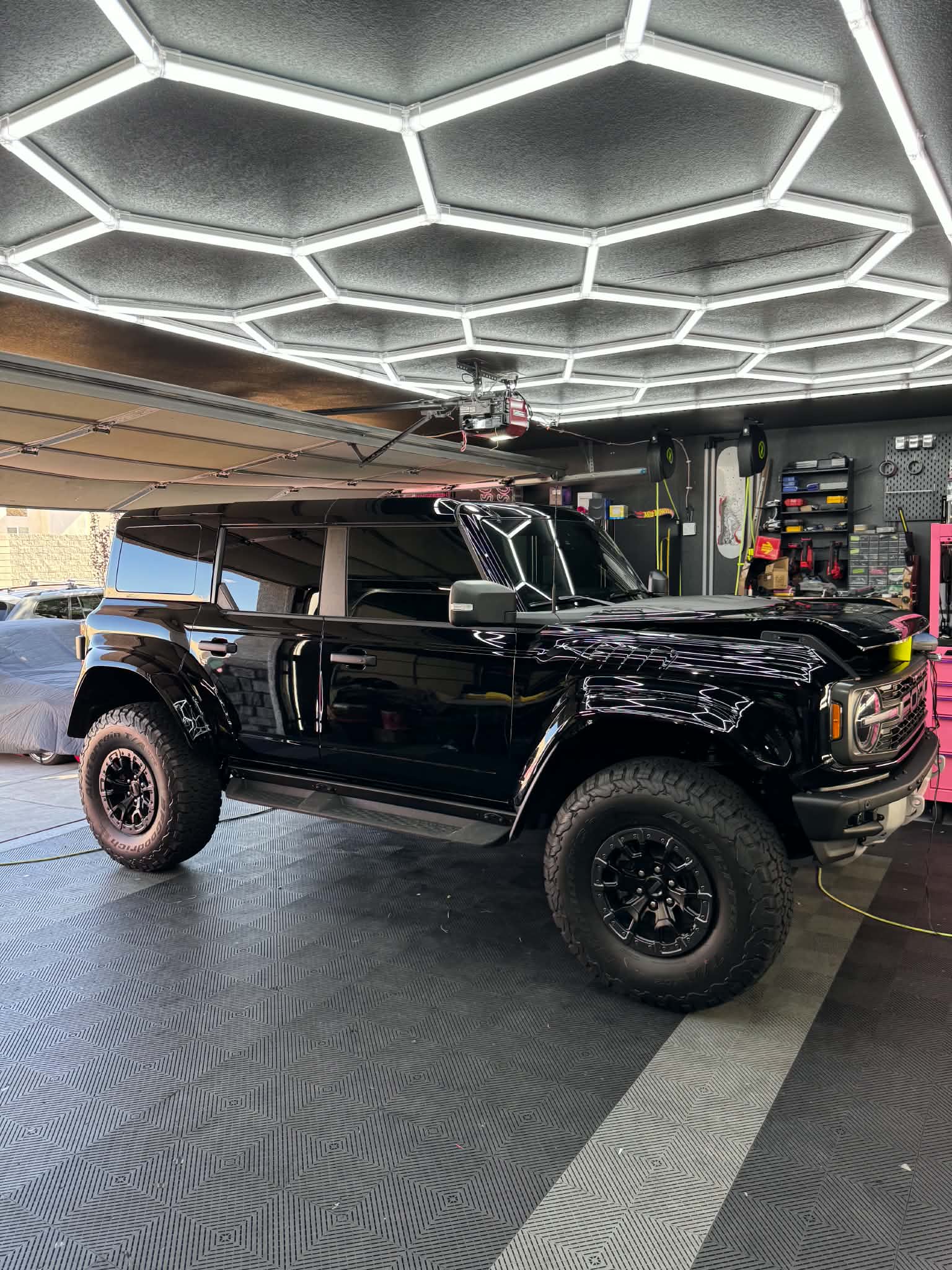 Black Ford Bronco with window tint inside a professional detail garage